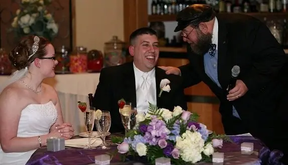 wedding officiant laughing with couple