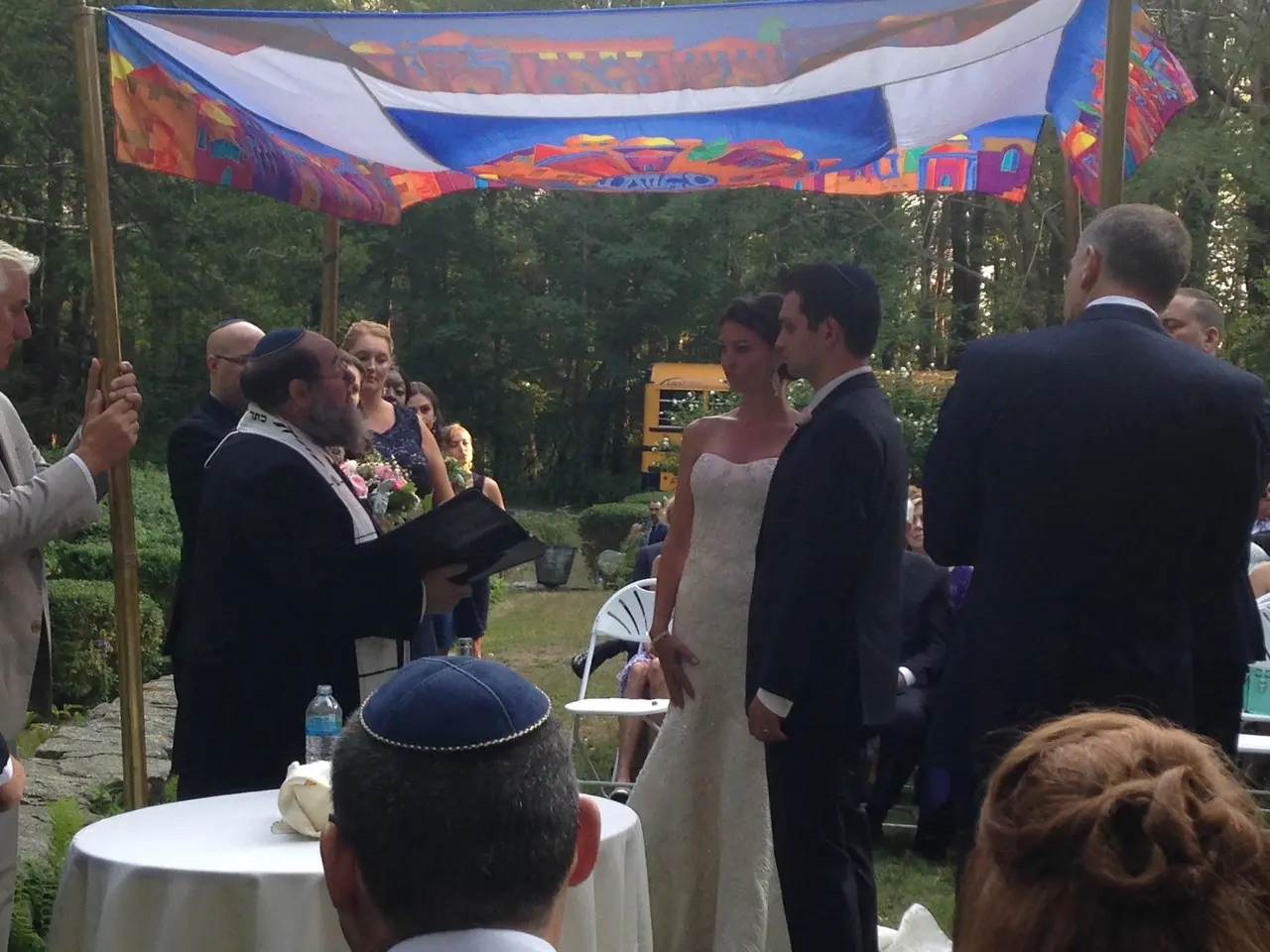 bride and groom under colorful chuppah