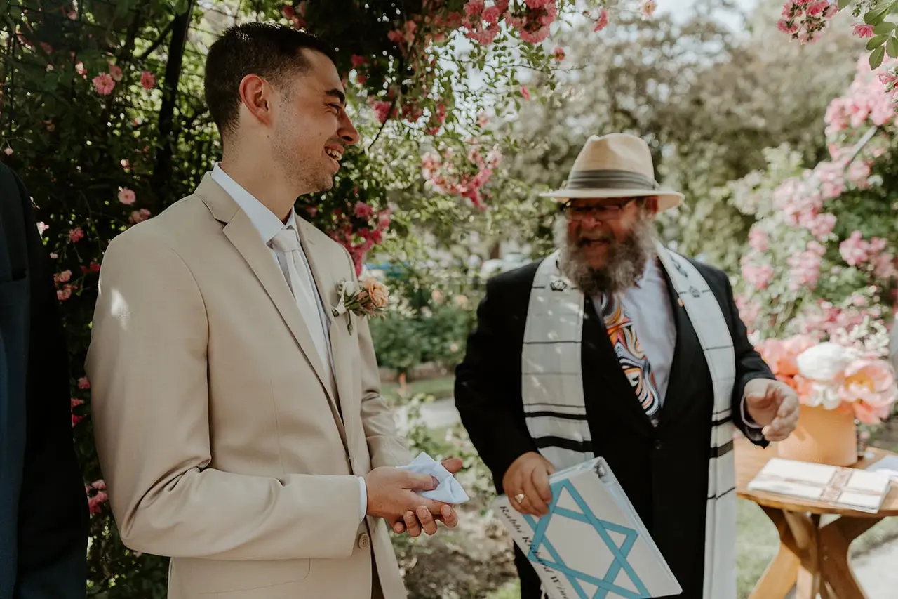rabbi richard winer laughing with groom during wedding ceremony