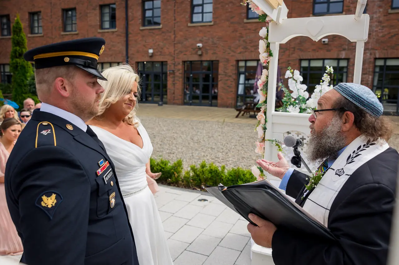 couple saying vows while rabbi richard winer officiates